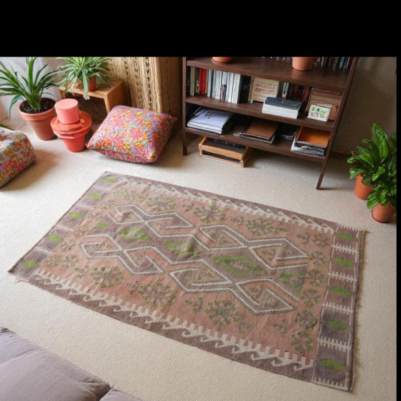 Turkish kilim-style wool rug with geometric patterns in muted rose and green tones
